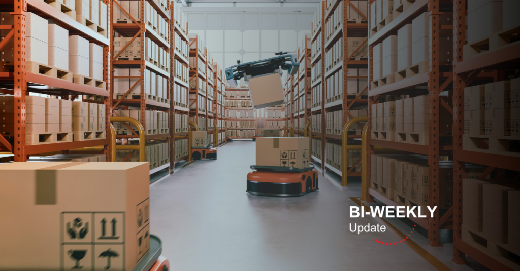 Autonomous warehouse robot lifting a box between tall orange shelving filled with parcels.